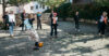 Das Foto zeigt eine Gruppe von Menschen in einem Innenhof, die zusammen Fussball spielen.