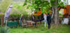 Das Foto zeigt eine Gruppe von Menschen, die in einem Garten gemeinsam etwas tun.